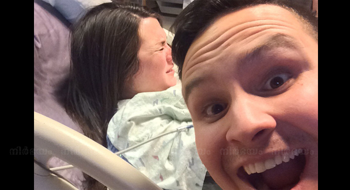 grinning-man-takes-selfie-as-his-suffering-wife-gives-birth-in-the-background